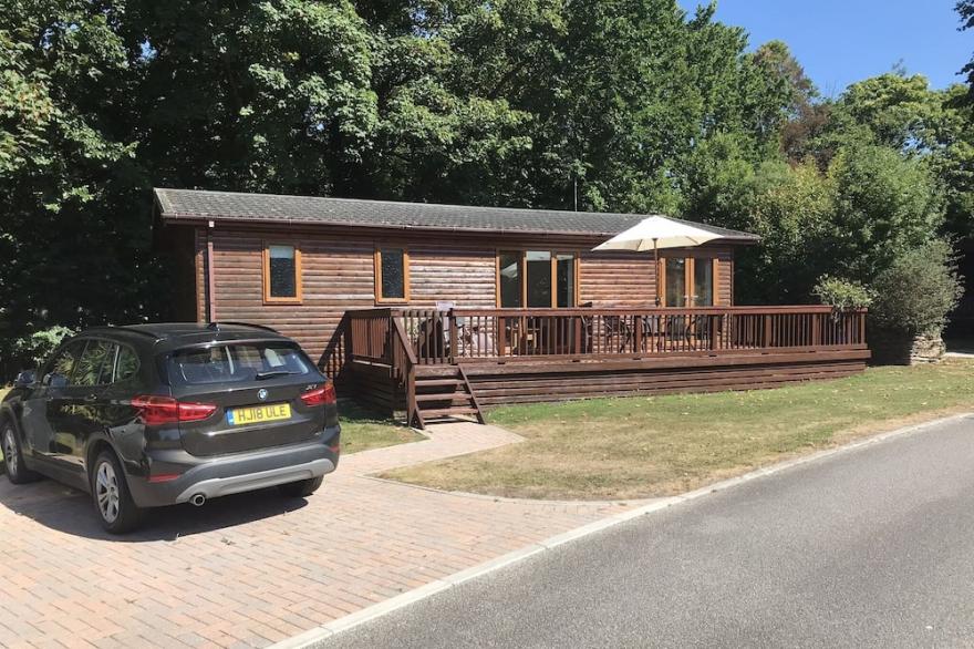 Modern Lodge Situated In a Quiet Tree-Lined Development. Access To A Shared Pool