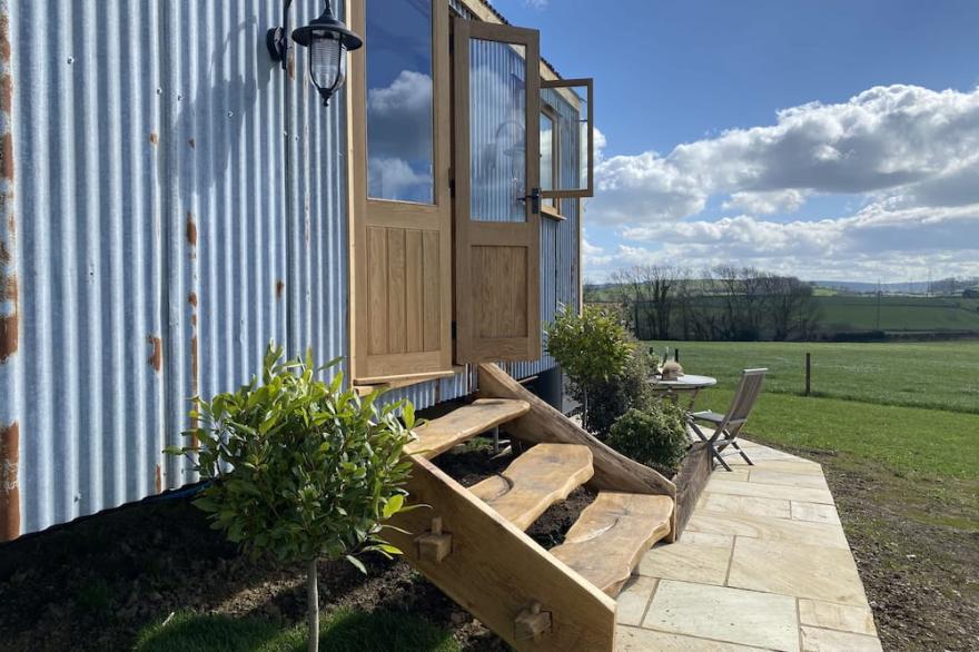 This bespoke handmade shepherd's hut, has a stylish modern interior which includes a well-equipped k