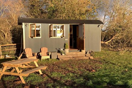 Luxury heated shepherd's hut in field location.